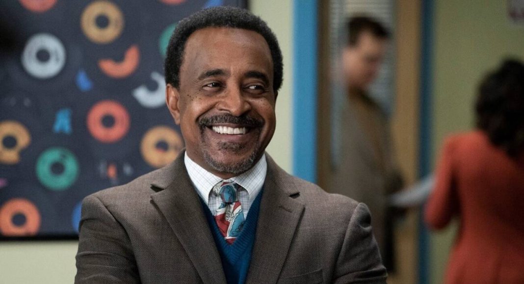 tim meadows Homem sorrindo com blusa social e gravata colorida.