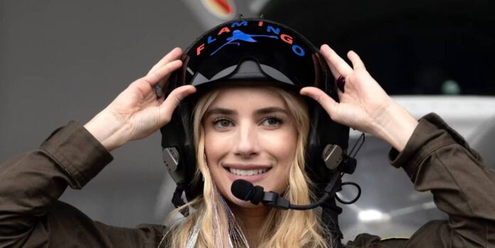 Mulher ajustando capacete de piloto com microfone.