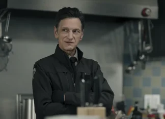 Homem com expressão pensativa em uma cozinha.