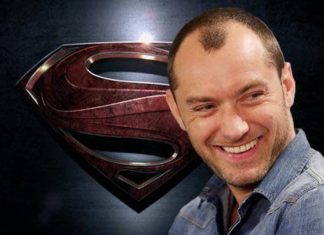 Homem sorridente com símbolo de Superman ao fundo.