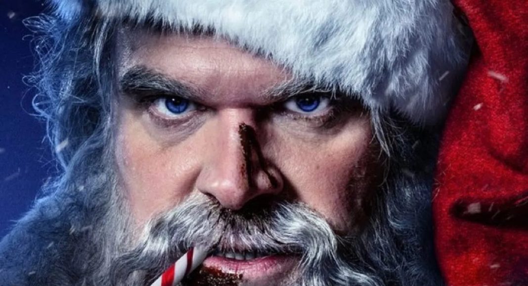 Papai Noel com expressão séria, segurando bengala doce.