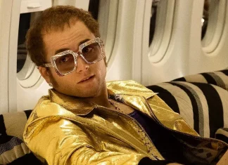 Homem com óculos de sol dourados em avião.