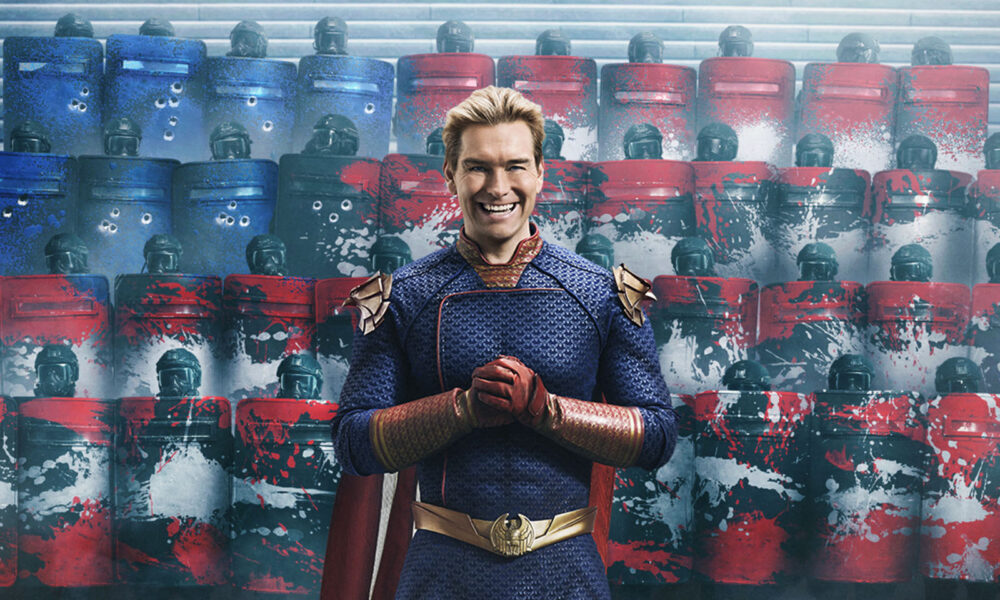 Homem de uniforme de super-herói sorrindo em frente a escudos coloridos.