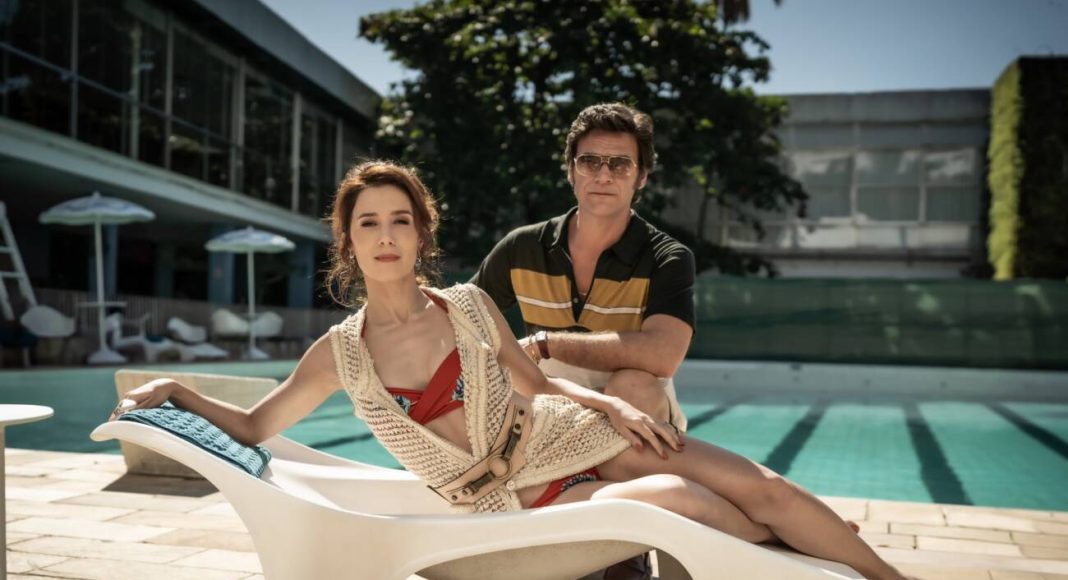 Casal em piscina ensolarada de hotel.