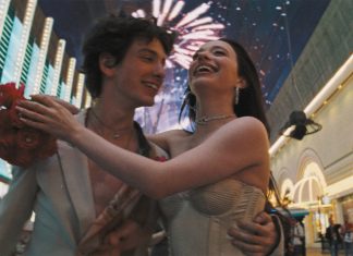Casal sorrindo com fogos de artifício ao fundo