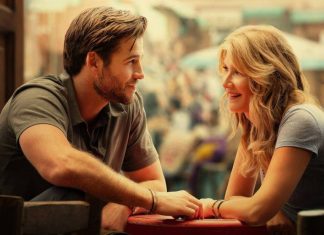 Casal sorridente se olhando em mesa de café.