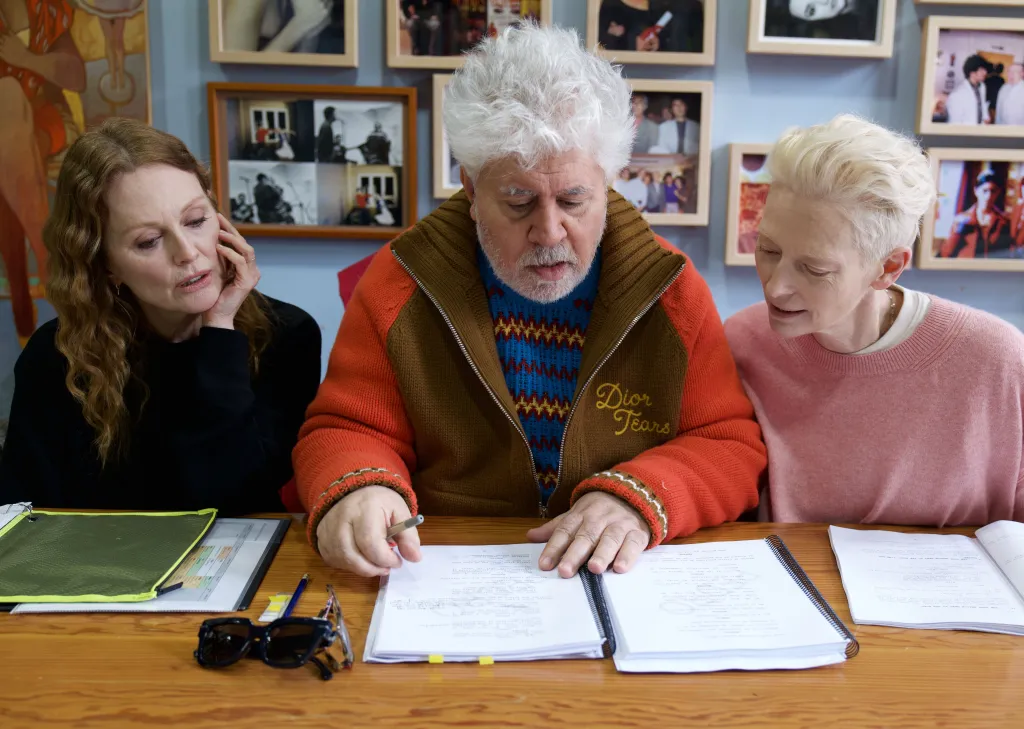 Três pessoas revisando documentos juntos em mesa.