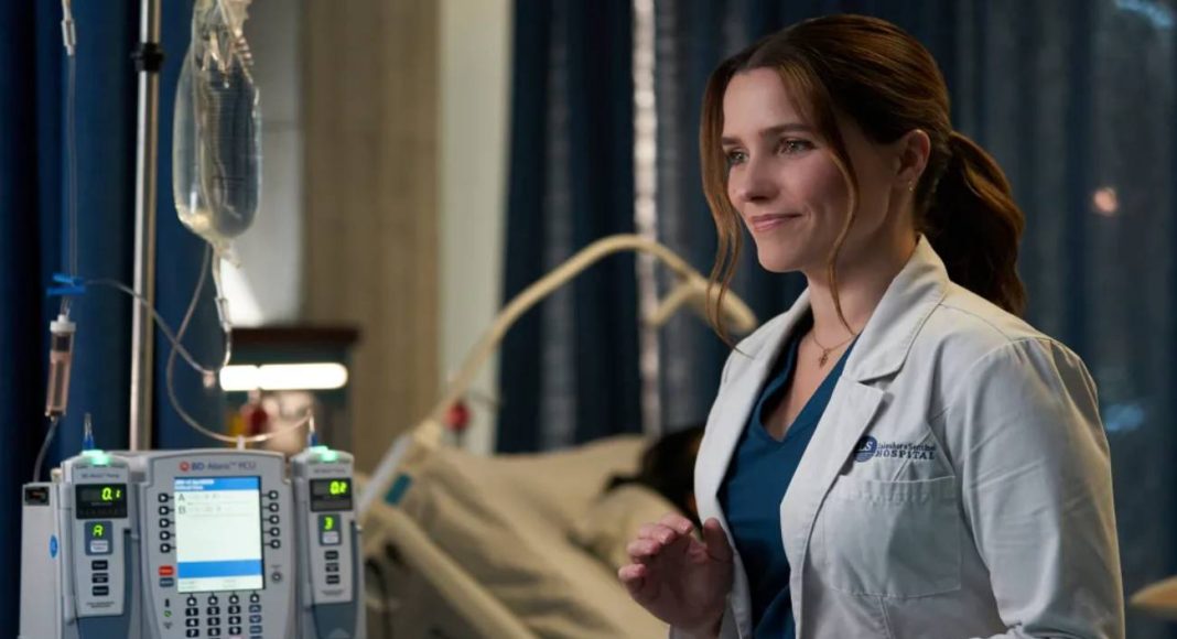 Médica sorrindo ao lado de equipamento hospitalar
