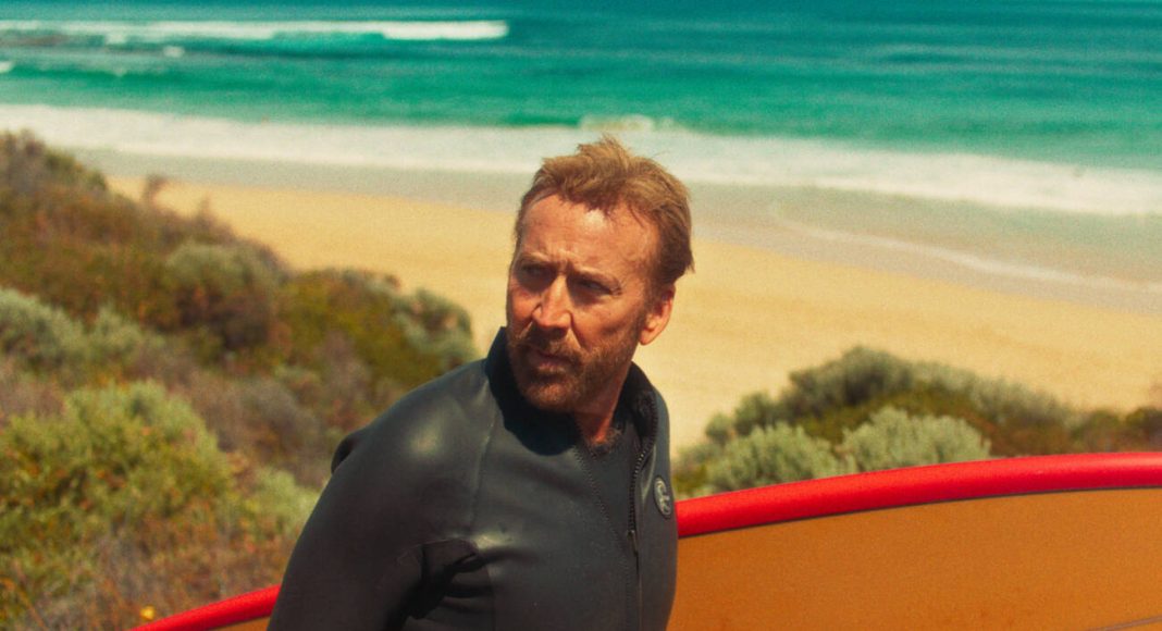 Surfista com prancha na praia ensolarada
