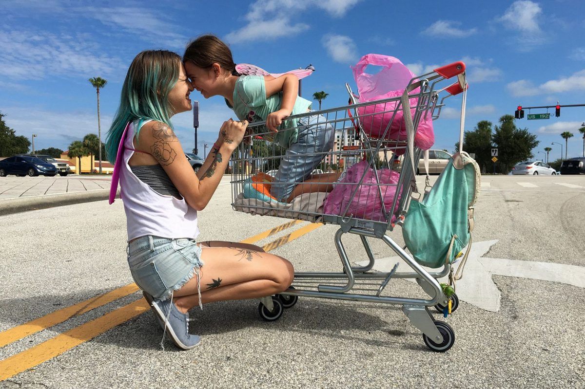 Mãe e filha brincando com carrinho de compras.