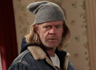 Homem com gorro cinza, olhando sério.