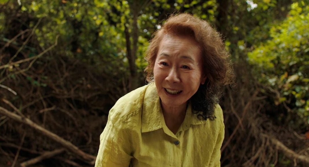 Mulher sorrindo em floresta verde.