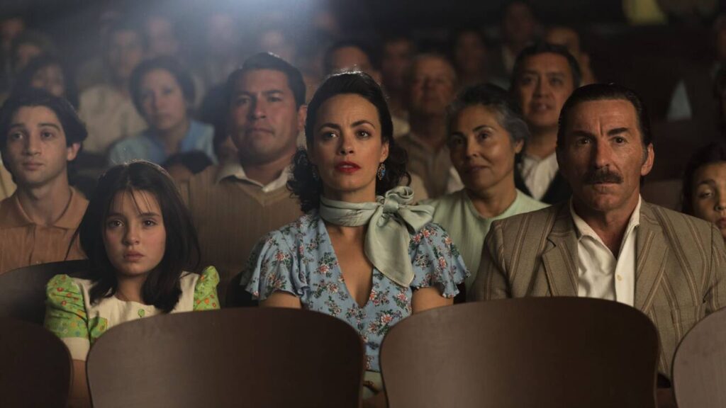 Pessoas assistindo a filme em cinema lotado.