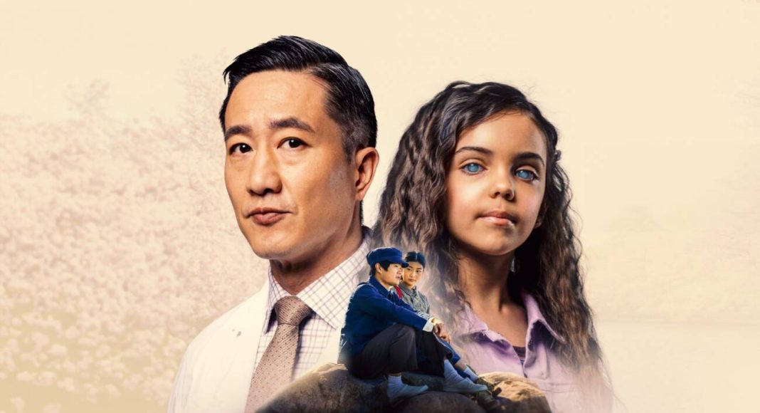 Homem e menina olhando à frente, cenário neutro.