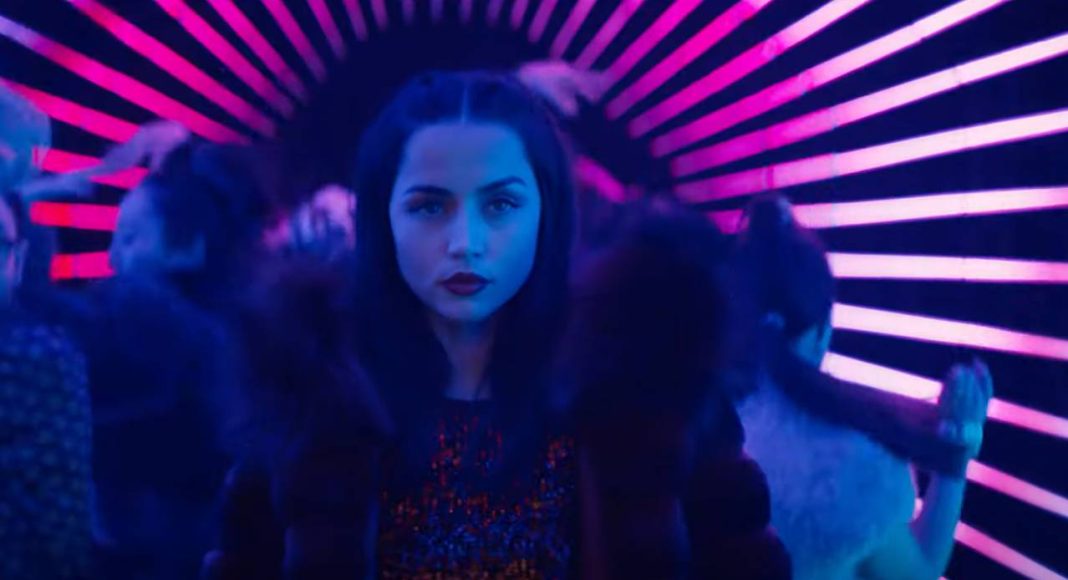 Mulher em túnel colorido neon dançando à noite.