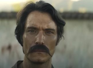 Homem com bigode em cena de filme.