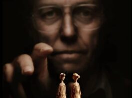 Pessoa atrás de figuras de madeira.