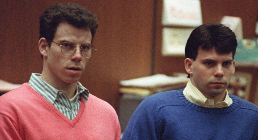 Dois homens em tribunal, suéteres coloridos.