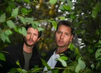 Dois homens em floresta, olhando atentos.