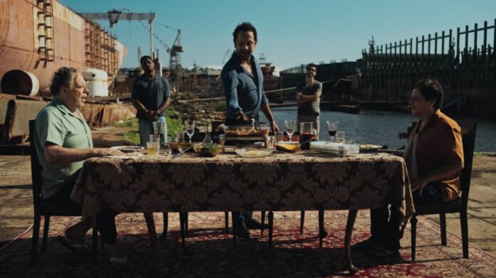 Pessoas jantando ao ar livre em estaleiro.