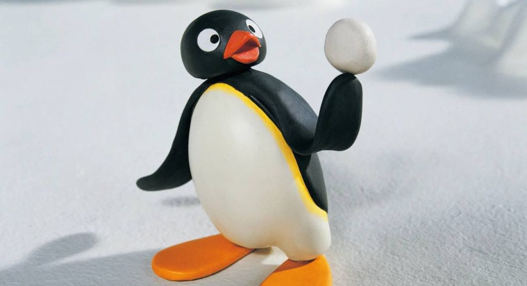 Pinguim de massinha segurando um ovo.