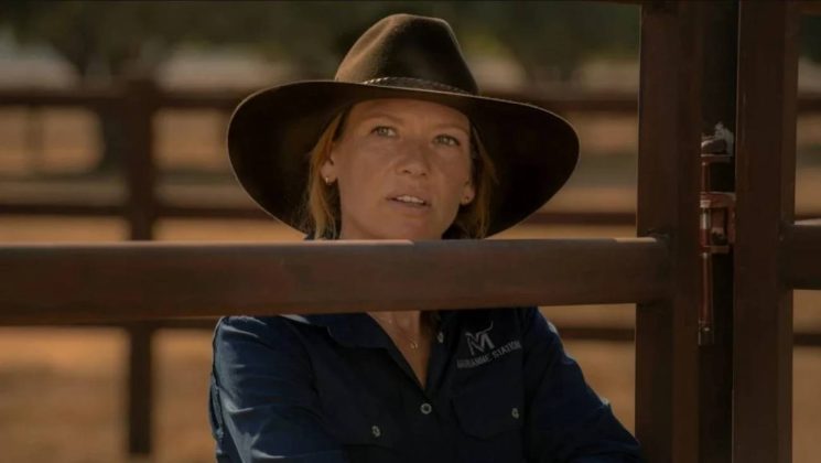Mulher com chap&eacute;u de cowboy em fazenda.