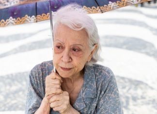 Crítica | Vitória – Fernanda Montenegro BRILHA em Atuação Corajosa Baseada em História Real Idosa com guarda-chuva na calçada de mosaico.