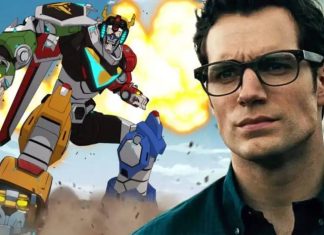 Robô gigante próximo a homem de óculos.