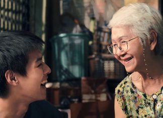 Idosos sorrindo em conversa amigável.