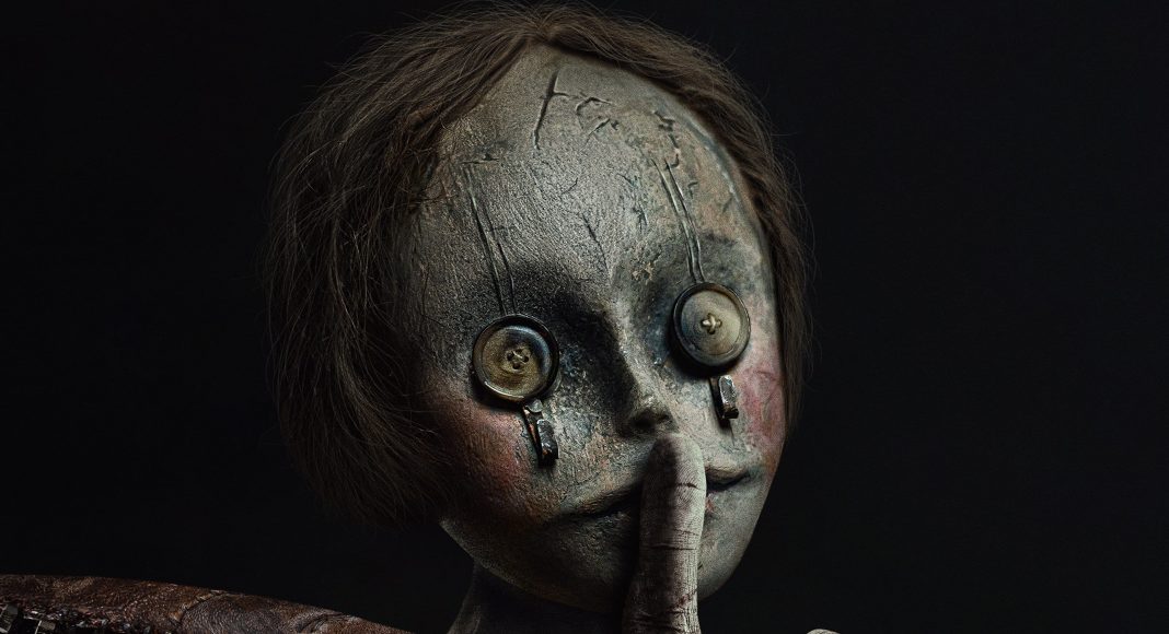 Boneca assustadora com botões nos olhos.