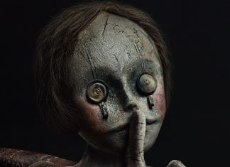 Boneca assustadora com botões nos olhos.