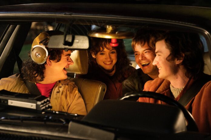 Grupo de amigos sorrindo dentro do carro à noite.