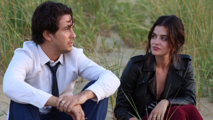 Casal conversando sentado na praia, cercado por plantas.