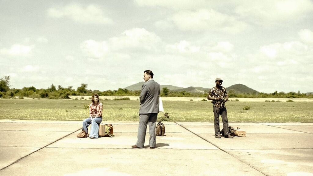 Três pessoas esperando em uma pista de pouso vazia