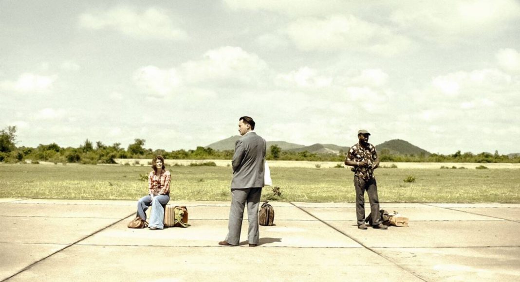 Três pessoas esperando em uma pista de pouso vazia