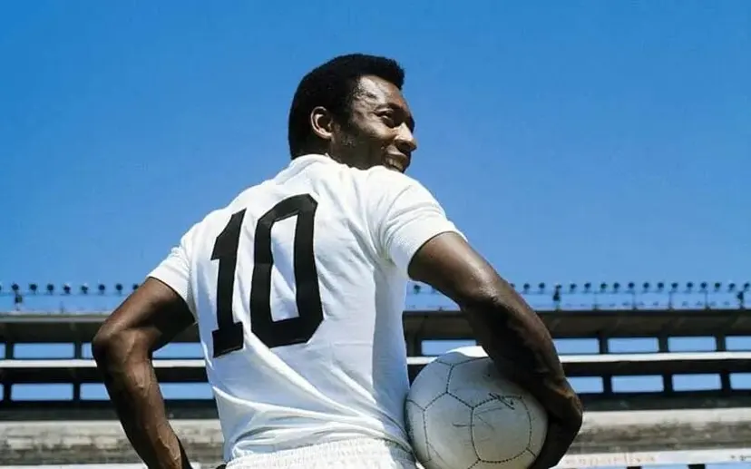 Jogador de futebol segurando bola com camisa número 10