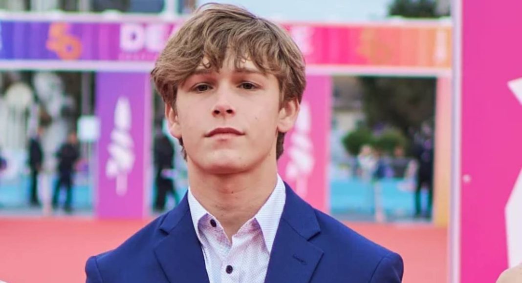 Jovem homem em terno azul em evento ao ar livre