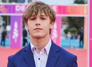 Jovem homem em terno azul em evento ao ar livre