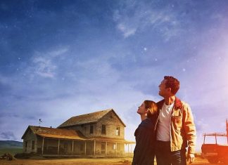 Casal observa céu estrelado ao lado de casa rural