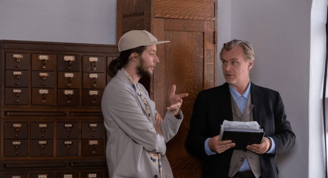 Dois homens conversando perto de arquivo antigo