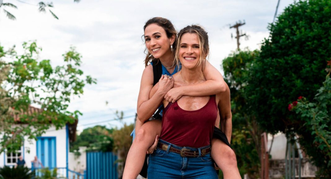 Duas mulheres sorridentes brincando de cavalinho na rua
