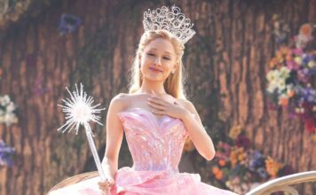 Princesa loira com tiara e varinha em cenário floral