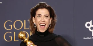 Atriz sorridente segurando troféu em premiação