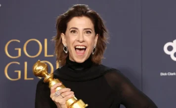 Atriz sorridente segurando troféu em premiação