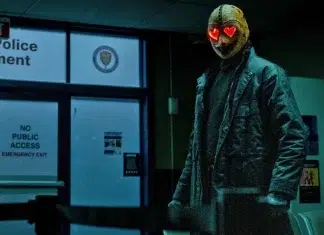Homem com máscara e olhos vermelhos na delegacia