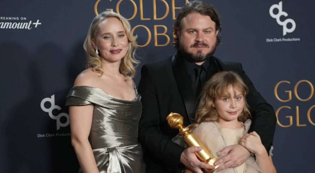 Coroteirista Mona Fastvold, Brady Corbet e a filha do casal no Globo de Ouro 2025. (Foto: Divulgação/Golden Globes)