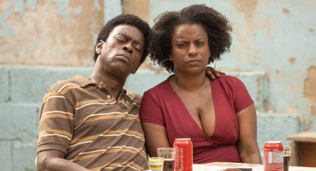 Casal sério sentado à mesa com bebidas