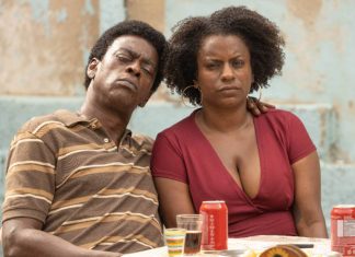 Casal sério sentado à mesa com bebidas