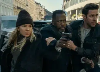 John Krasinski enfrenta inimigo mortal no trailer LEGENDADO de ‘Jack Ryan: Guerra Fantasma’; Confira! Tense street chase with three adults fleeing; center man points a pistol while a woman and another man back him as they run down a city street far from danger.
