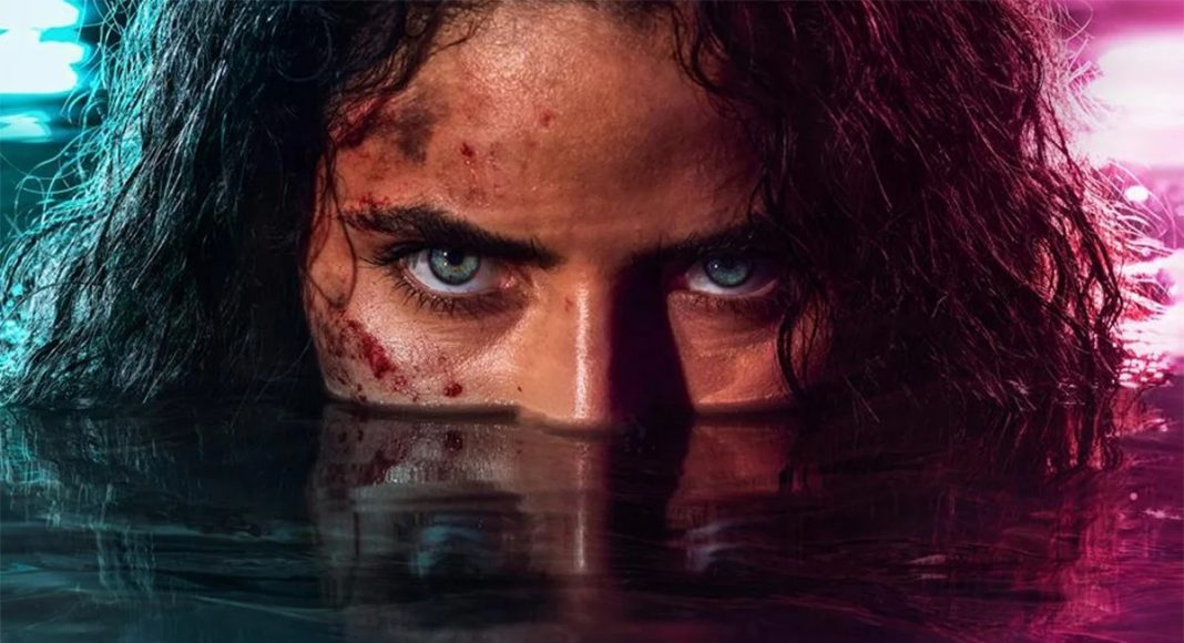 m.i.a. 3 Close-up of a person with blue eyes staring over waterline, blood on the cheek, dark wet hair, under neon blue and pink lighting.